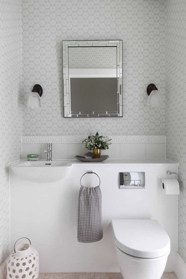 Phòng tắm có màu chủ đạo trắng, phần tường ốp gạch hoạ tiết, phần bồn rửa và bồn cầu thiết kế liền với khối bàn giúp tối ưu diện tích và dễ dàng vệ sinh.
