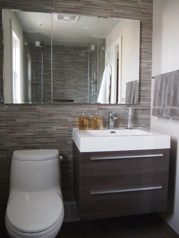 Phòng tắm có 2 màu gạch khác nhau ở mỗi mảng tưởng trông đỡ nhàm chán, bồn cầu để cạnh bồn rửa mặt khá gọn gàng.